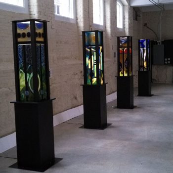 18”x square 88”<br>
Luminary Totems<br>
Fused glass, LED custom wood pedestals<br>
Newmarket, NH<br>
An art event installation<br>
Artist: Caroline Parent
