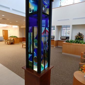 18” square by 88” height<br>
Fused glass art legacy donor recognition free standing work of art<br>
Northwestern Medical Center<br>
St. Albans, VT<br>
Artist: Caroline Parent